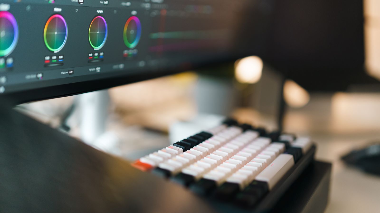 Professional video editing workspace with color controls and editing keyboard